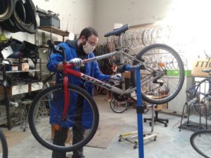 Un mécanicien répare un vélo avec masque
