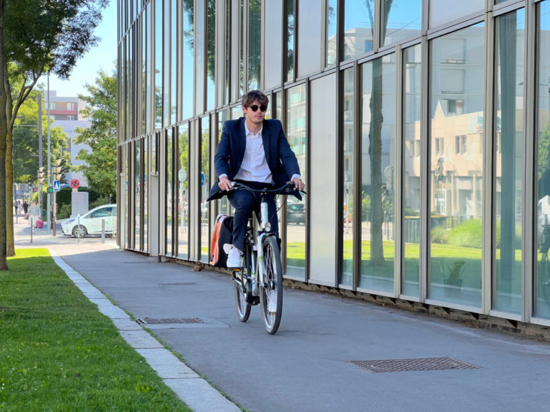 Homme en costume sur un vélo électrique avec sacoche à Saint-Étienne