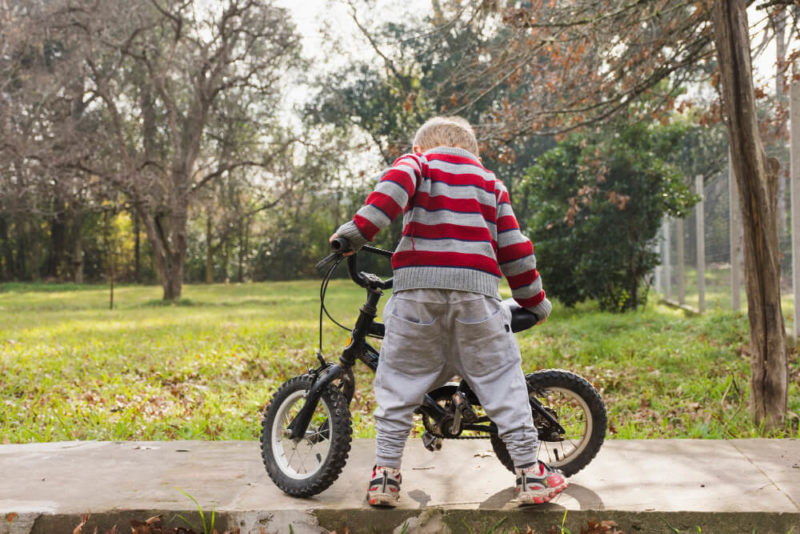 Enfant regardant son vélo dans un parc
