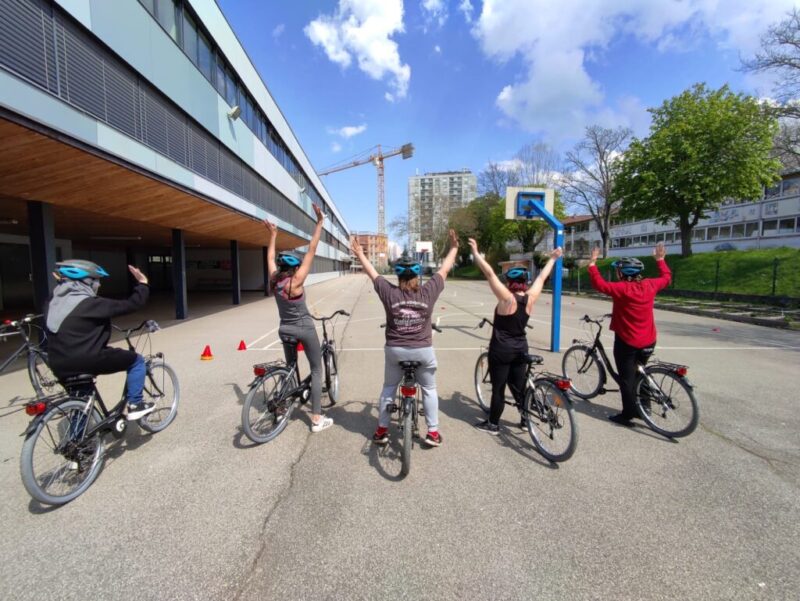 cinq apprenants adultes de la vélo-école d'Ocivélo, les bras vers le ciel